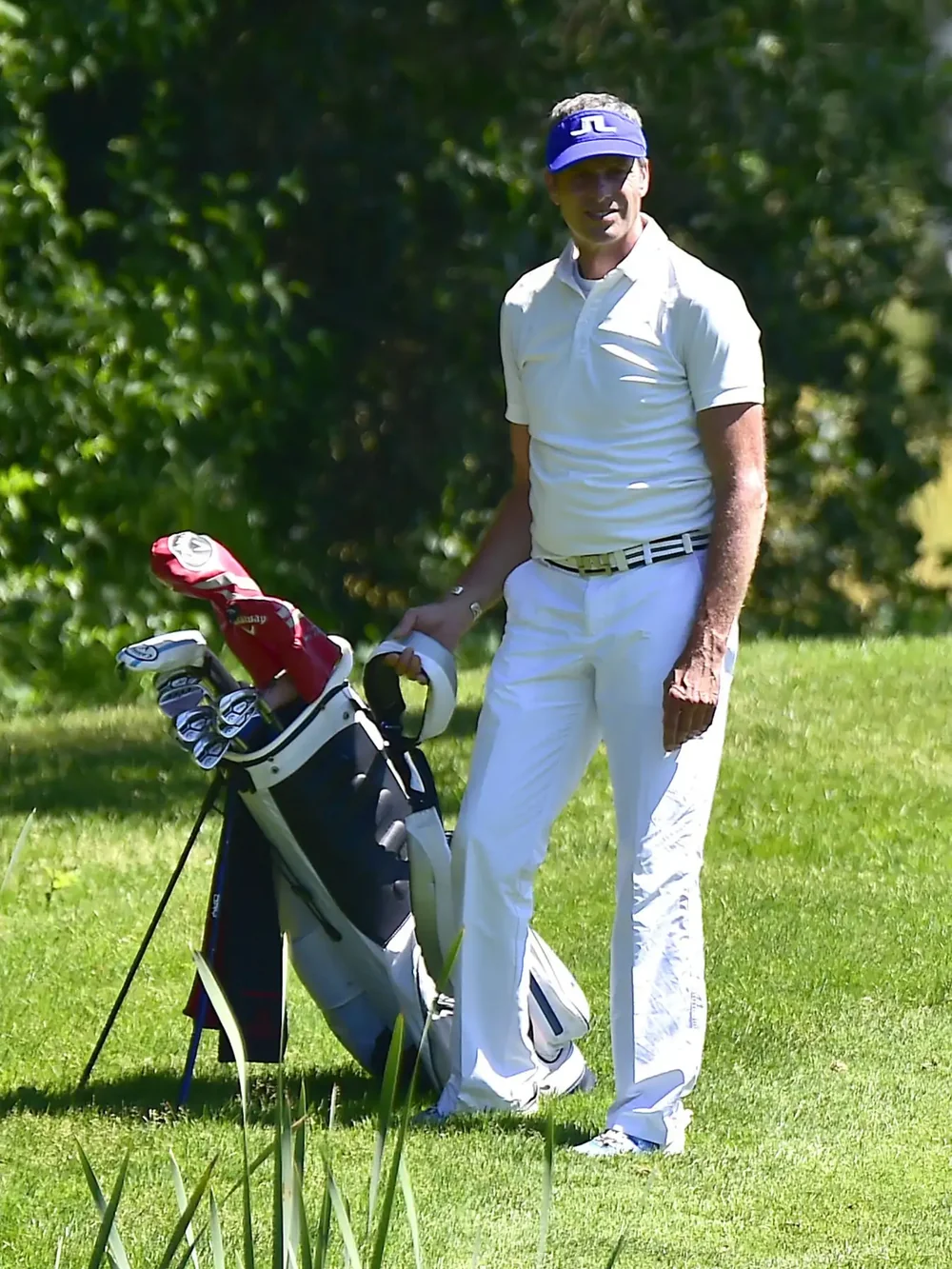 Norbert Endres beim Golfen, am Golfbag stehend