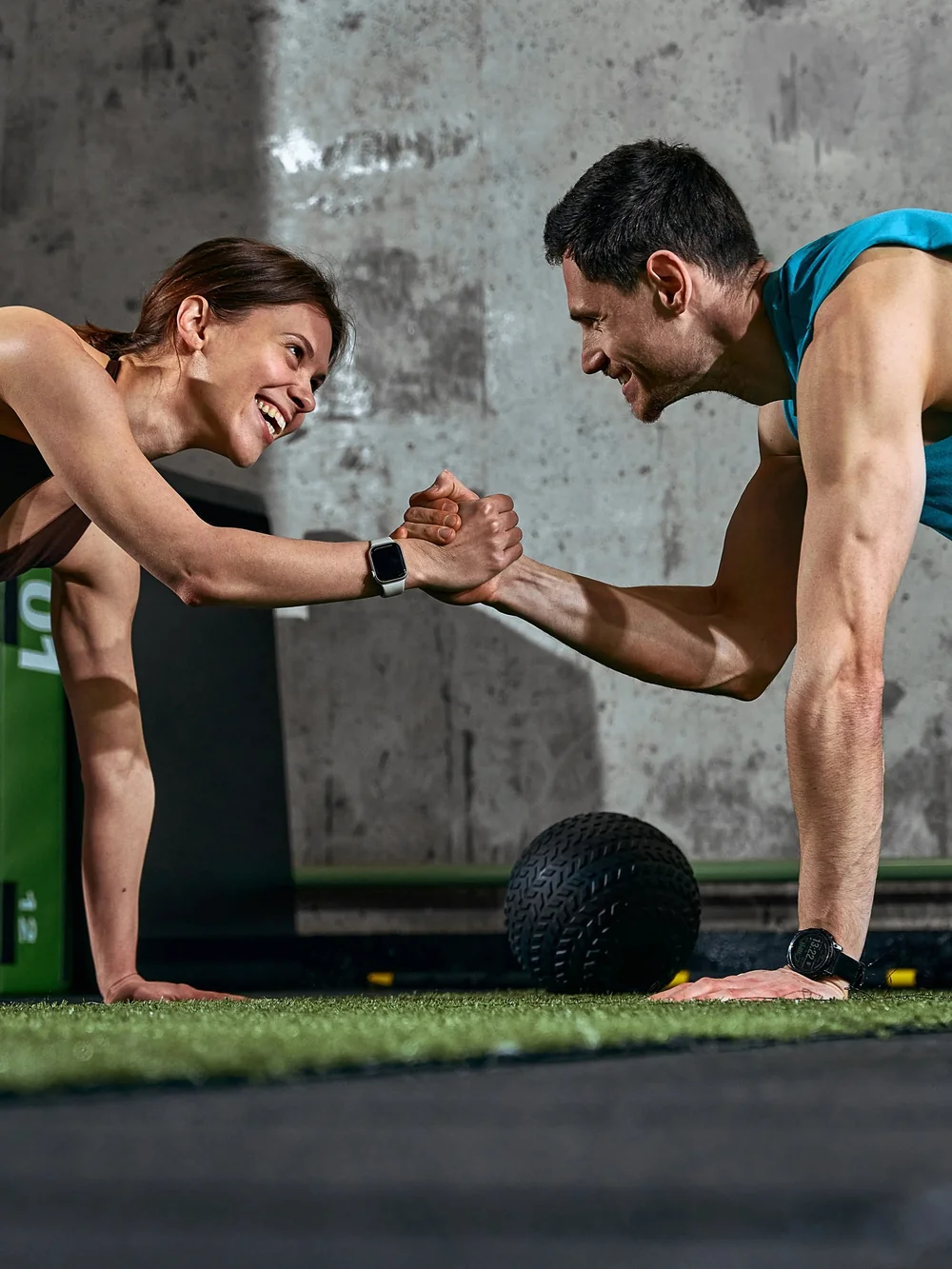 Personal Training: zwei Trainierende beim High Five in der Liegestützposition